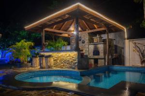 a swimming pool with a gazebo in a backyard at night at Treasure Villa in Praslin