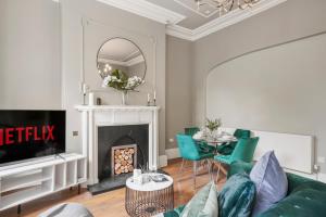 a living room with a couch and a fireplace at Lux Georgian House in Yorkshire - Parking - Garden in Wakefield