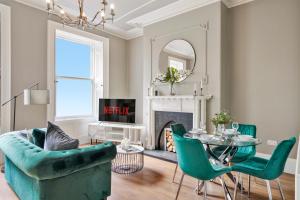 a living room with a green couch and a table at Lux Georgian House in Yorkshire - Parking - Garden in Wakefield