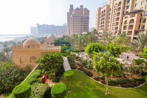 a park in the middle of a city with tall buildings at Bespoke Holiday Homes - Palm Jumeirah- 2 Bedroom with Gym, Beach & Pool Access, Fairmont South in Dubai