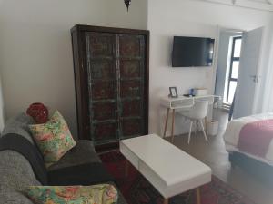 uma sala de estar com um sofá e uma mesa em The Rez Guesthouse em Walvis Bay