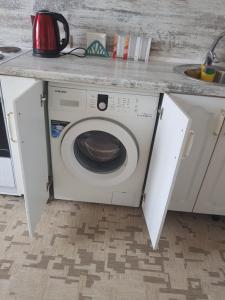 a washing machine under a counter in a kitchen at квартира in Pavlodar