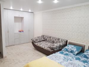 salon z kanapą i łóżkiem w obiekcie квартира w mieście Pawłodar