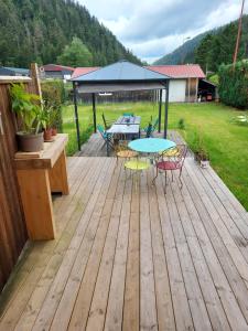 a wooden deck with a table and chairs on it at Chez Laetitia in Gérardmer