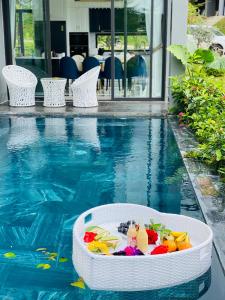 ein Pool mit einer Wanne voller Spielzeug und Getränke in der Unterkunft Amun Villa - Venuestay in Vĩnh Phúc