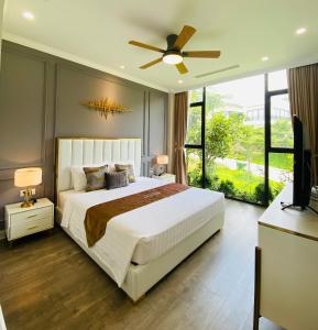 ein Schlafzimmer mit einem großen Bett und einem Deckenventilator in der Unterkunft Amun Villa - Venuestay in Vĩnh Phúc + 42 Fotos