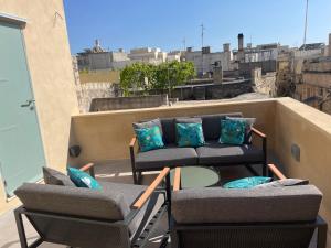 balkon z 2 krzesłami i stołem na dachu w obiekcie 60 Indri Borg Townhouse w mieście Rabat