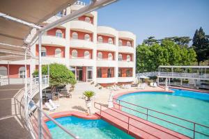 un hotel con piscina di fronte a un edificio di Villa Dei Misteri a Pompei