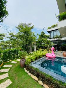 ein Swimmingpool mit einer rosa Gummiente in einem Hof in der Unterkunft Amun Villa - Venuestay in Vĩnh Phúc
