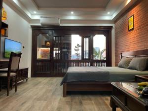 a bedroom with a bed and a desk and a television at Eco nest in Hanoi