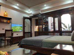 a bedroom with a bed and a flat screen tv at Eco nest in Hanoi