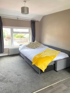 1 dormitorio con 1 cama grande con manta amarilla en Annex - Garden View en Bristol