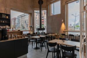 a restaurant with tables and chairs and large windows at The More Hotel Västra Hamnen in Malmö