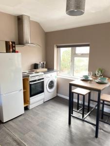 een keuken met een witte koelkast en een tafel bij Annex - Garden View in Bristol