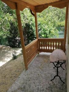 a wooden gazebo with a chair on a patio at Casa de oaspeti adorabila aproape de natura in Sărata-Monteoru