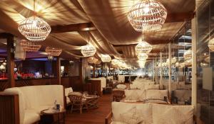 a restaurant with white tables and chandeliers at Radisson Blu Hotel & Resort, Abu Dhabi Corniche in Abu Dhabi