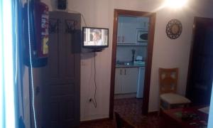 a television on a wall next to a kitchen at LAS CALAÑAS DE SETENIL in Setenil +9 photos