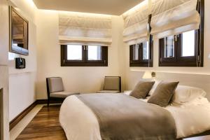 1 dormitorio con 1 cama grande y 2 sillas en 12 Months Resort & Spa, en Tsagkarada
