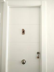 Una puerta blanca con una perilla metálica. en Casa Herrerillo Cazorla, en Cazorla