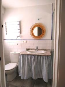y baño con lavabo, aseo y espejo. en Casa Herrerillo Cazorla, en Cazorla