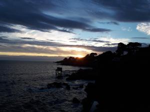 una puesta de sol sobre el océano con la puesta de sol en CLAIRE MARINE PORNIC, en Pornic