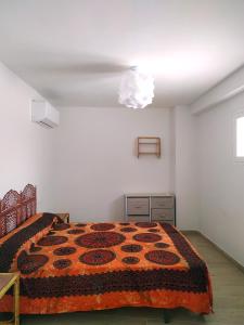 Un dormitorio con una cama con una manta naranja. en Casa Herrerillo Cazorla, en Cazorla