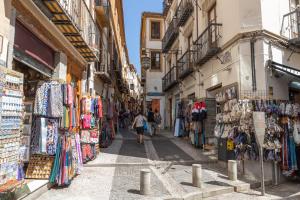 uma rua numa cidade velha com pessoas a andar por ela em El Almirez em Granada