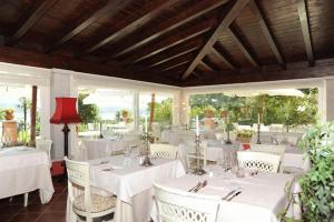una sala da pranzo con tavoli bianchi e sedie bianche di Villa Baroni a Lomnago