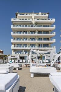 un hotel en la playa con camas y sombrillas blancas en Vistamare Suite, en Lido di Savio