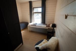 a small room with a bed and a window at Norlight Cottages Ivalo - Tuli in Ivalo