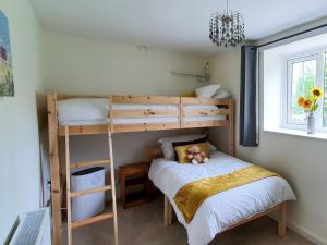 a bedroom with two bunk beds and a bed at Colby Hall Cottage in Colby