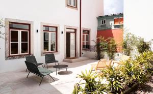 un patio avec des chaises et des plantes devant un bâtiment dans l'établissement Casa do Correio @ Casas do Pátio (1), à Coimbra