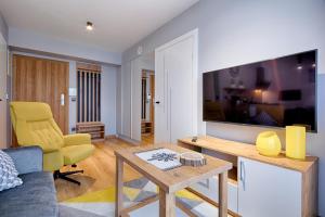 Televízia a/alebo spoločenská miestnosť v ubytovaní GórSKI Przystanek Apartament Parzenica i Rozeta