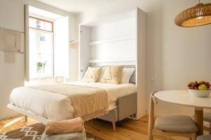 - une chambre blanche avec un lit et une table dans l'établissement Casa do Correio @ Casas do Pátio (1), à Coimbra