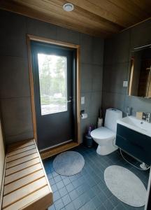 a bathroom with a toilet and a sink and a window at Norlight Cottages Ivalo - Tuli in Ivalo