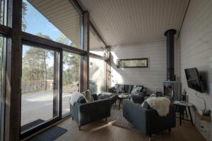 a living room with couches and a large window at Norlight Cottages Ivalo - Tuli in Ivalo