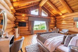 1 dormitorio con 1 cama en una cabaña de madera en The Log Cabins at The Vu en Bathgate