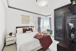 a bedroom with a white bed and a tv at Gala by Kozystay - Thamrin in Jakarta