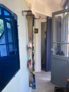 un snowboard suspendu sur un mur à côté d'une porte dans l'établissement Le « studio sur la Neste » dans le centre d’Arreau, à Arreau