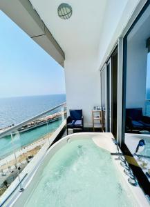 una vasca da bagno in una camera con vista sull'oceano di Damac Al Jawharah Apartment a Gedda