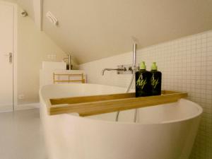 a white bath tub in a bathroom with a sink at La Guirtelle in Lainsecq +61 photos