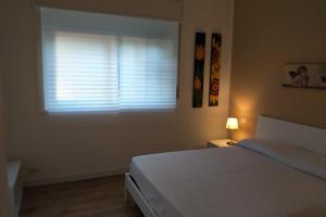 Schlafzimmer mit einem Bett und einem Fenster mit Jalousien in der Unterkunft CARMEN E FEDE in Giardini-Naxos