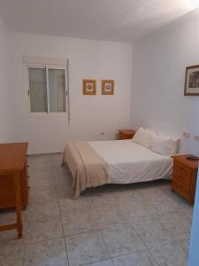 a white bedroom with a bed and a desk at HOTEL ORIANA in Badajoz