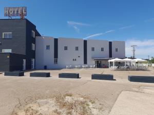 a building with tables and chairs in a parking lot at HOTEL ORIANA in Badajoz