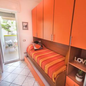 una camera con armadi arancioni e un letto di Salento Delizioso appartamento con ampia corte a Torre San Giovanni Ugento