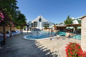 a large pool with a fountain in front of a building at Spa Residence Carbona Great Time Apartman in Hévíz