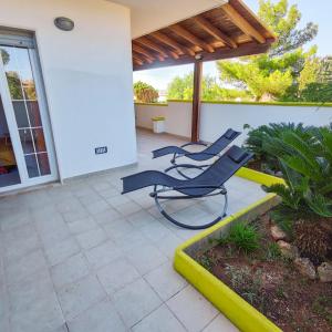 a patio with two blue chairs on a porch at Salento Delizioso appartamento con ampia corte in Torre San Giovanni Ugento