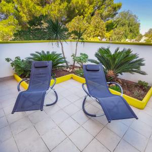 two blue chairs sitting on a patio at Salento Delizioso appartamento con ampia corte in Torre San Giovanni Ugento +26 photos