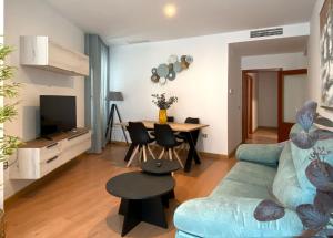 a living room with a blue couch and a table at Gran Hotel Don Manuel in Cáceres