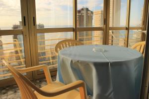 a dining room table with chairs and umbrellas at Apartamentos Viña del Mar in Benidorm